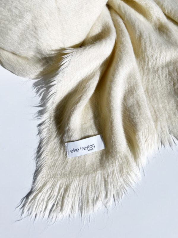 Der winterweisse Kuschelschal ist der Blickfang für jedes Herbst und Winteroutfit. Das Material besteht aus Designer leftover fabric 100% Viscose. Gewaschen wird der Schal mit 30 Grad im Wollprogramm und es ist nicht für den Trockner geeignet. Erwerben kannst du das Designer Stück bei elke freytag wien in der Lindengasse 14, im siebten Bezirk und im Online Store. Alle Designs der Marke elke freytag sind fair, nachhaltig und aus hochwertigen Materialen produziert. Der Schal kostet € 58,00 und trägt das Prädikat Handmade in WIEN